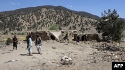 باشندگان در نزدیکی یک خانه آسیب‌دیده پس از حمله هوایی پاکستان در ولسوالی برمل ولایت پکتیکا