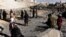 FILE: Afghan security personnel gather at the site of a suicide attack at a police compound in Maiwand district of Kandahar province on December 22.