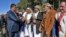 Yemen -- A member of the Huthi delegation (L) returning from peace talks in Sweden shake hands with supporters upon arrival at Sanaa International Airport in the Yemeni capital on December 14, 2019. - The Huthi rebel delegation returned on December 14 to 