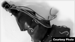 Инсталляция CelloClaus - имитация футляра виолончели из искусственной кожи, переходящего в эрзац-портфель с порванными «струнами-проводами-артериями»