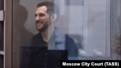 Trevor Reed stands inside a defendants' cage during a court hearing in Moscow in June 2021.