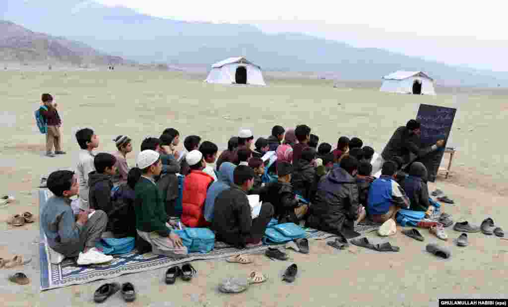 Afghan refugees, who have voluntarily returned from neighboring Pakistan with assistance from the United Nations High Commissioner for Refugees (UNHCR), attend an open-air school outside their temporary shelters in Laghman Province. (epa/Ghulamullah Habibi)