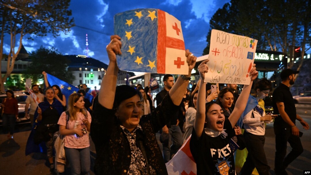 Protestari țin steagurilor europene și ale Georgiei în timp ce mărșăluiesc pe străzile din Tbilisi în semn de protest după ce parlamentarii au promovat o lege controversată a „influenței străine”. 22 aprilie 2024.
