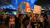 Protestuesit mbajnë kopje të flamujve evropian dhe gjeorgjian teksa marshojnë rrugëve të kryeqytetit Tbilisi, për të protestuar kundër projektligjit për "agjentët e huaj", për të cilin kundërshtarët thonë se do ta minojë rrugën e Gjeorgjisë drejt BE-së, 22 prill 2024.