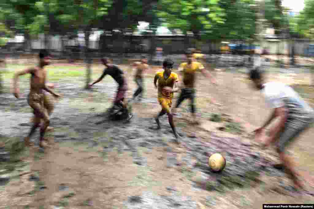 Boys play football on the muddy ground of a park on a rainy day in Dhaka, Bangladesh. (Reuters/Mohammad Ponir Hossain)