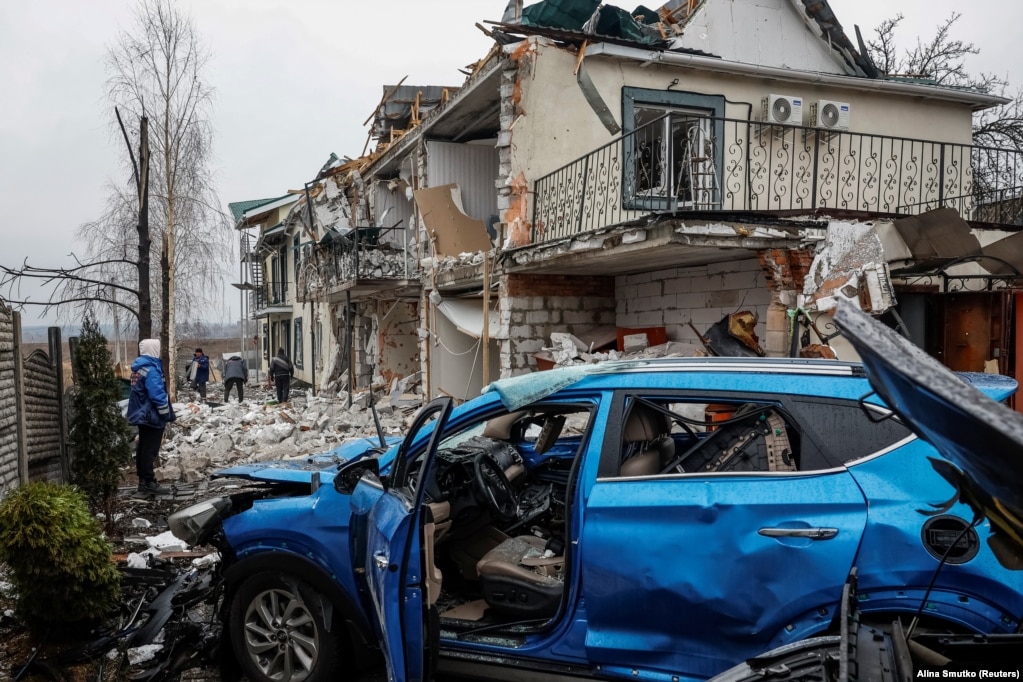 Një lagje banimi në Hostomel, afër Kievit, e fotografuar më 19 mars, pas një sulmi me dronë gjatë natës.Më 18 mars u njoftua për arritjen e një armëpushimi të pjesshëm, teksa Kremlini u zotua se do t'i ndalë sulmet ndaj objektivave "të energjisë dhe infrastrukturës", pas një bisede telefonike mes presidentit të Shteteve të Bashkuara të Amerikës, Donald Trump, dhe presidentit rus, Vladimir Putin.