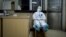 A medical worker in a protective suit takes a break during her night shift at a community health service center in Wuhan. 