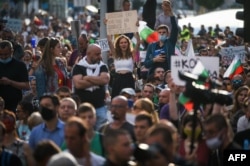 Protesters shout slogans and wave Bulgarian national flags during an anti-government protest in Sofia on July 13, 2020.