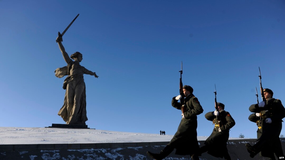 Honor guards march past the giant monument built to honor those who died in the World War II Battle of Stalingrad.