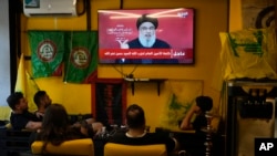 Libanezii urmăresc reacția liderului Hezbollah, Hassan Nasrallah, după exploziile pagerelor și stațiilor de emisie-recepție din ultimele zile. În timpul discursului, avioanele de luptă israeliene zboară deasupra Beirutului. 19 septembrie.