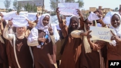 Ученички държат плакати по време на протест срещу нарушенията на Силите за бързо реагиране (RSF) срещу хората в Ел-Фашер, в Хартум, 3 ноември 2025 г.