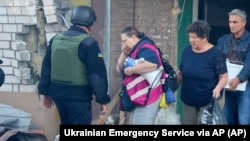 A photo provided by the Ukrainian Emergency Service shows residents evacuating their ruined home on September 29 after a Russian attack with guided bombs.