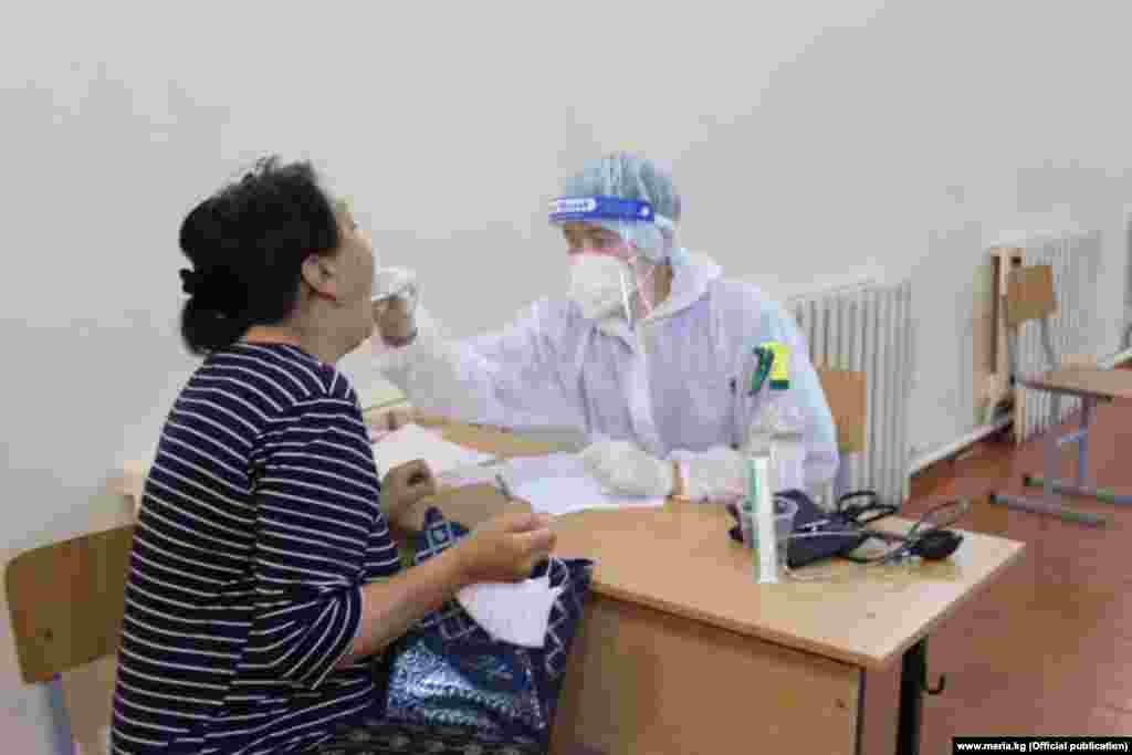 Бишкектеги убактылуу ооруканалардын биринде бейтаптан ПЦР тест алып жаткан медицина кызматкери.