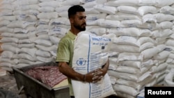 Palestinski radnik nosi vreću brašna Svjetskog programa za hranu u Pojasu Gaze, 22. maj 2025. 