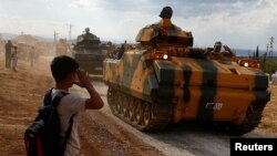 Türkiýäniň Reýhanly şäherçesindäki türk ýaragly güýçleri we ýoluň gyrasynda duran çaga