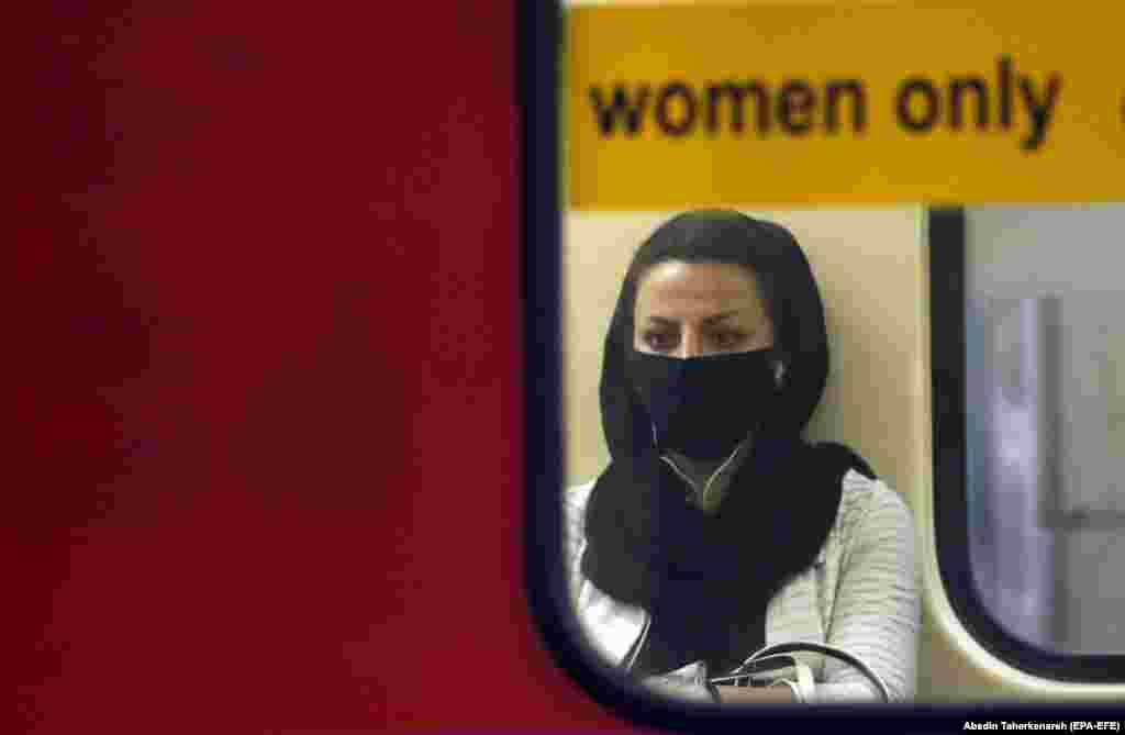 An Iranian woman wearing a face mask sits in a train in a Tehran subway station on June 10. (epa-EFE/Abedin Taherkenareh)