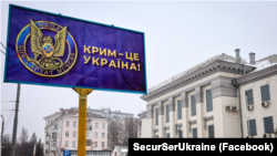 Билборд с эмблемой контрразведки СБУ и надписью, что Крым – это Украина, установленный возле посольства России в Украине. Киев, 24 февраля 2021 года