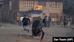 Kashmiris throw rocks at security personnel during a protest in Srinagar in August 2019.