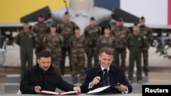 Ukrainian President Volodymyr Zelenskyy (left) met with his French counterpart, Emmanuel Macron, on November 17, at the Villacoublay air base near Paris, where they agreed to a deal on fighter jets.