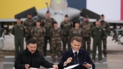 Френският президент Еманюел Макрон (дясно) и украинският президент Володимир Зеленски подписват споразумение във военновъздушната база Вилакублей близо до Париж, 17 ноември 2025 г. 