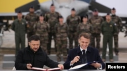 Ukrainanyň prezidenti Wolodymyr Zelenskiý (çepde) 17-nji noýabrda Parižiň golaýyndaky Willakouble howa bazasynda fransuz kärdeşi Emmanuel Makron bilen duşuşdy we olar söweş uçarlary barada ylalaşyga gol goýdular.