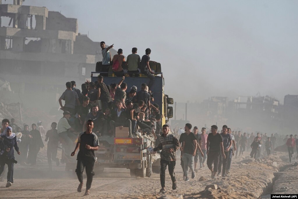 Banorë të Gazës në një kamion të ngarkuar me ushqime dhe ndihma tjera humanitare.