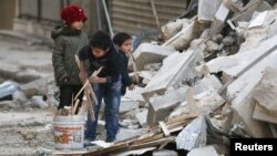 Սիրիա - Հալեպի թաղամասերից մեկում երեխաները վառելափայտ են հավաքում ռմբակոծության հետևանքով ավերված շենքի փլատակներից, նոյեմբեր, 2016թ․