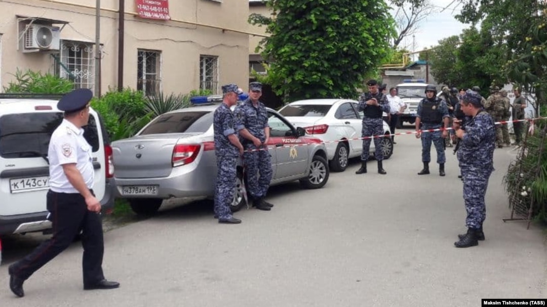Police investigators work on the street in Sochi where a man shot two bailiffs dead as they attempted to evict him and his family from their home. 