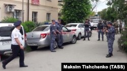 Police investigators work on the street in Sochi where a man shot two bailiffs dead as they attempted to evict him and his family from their home. 