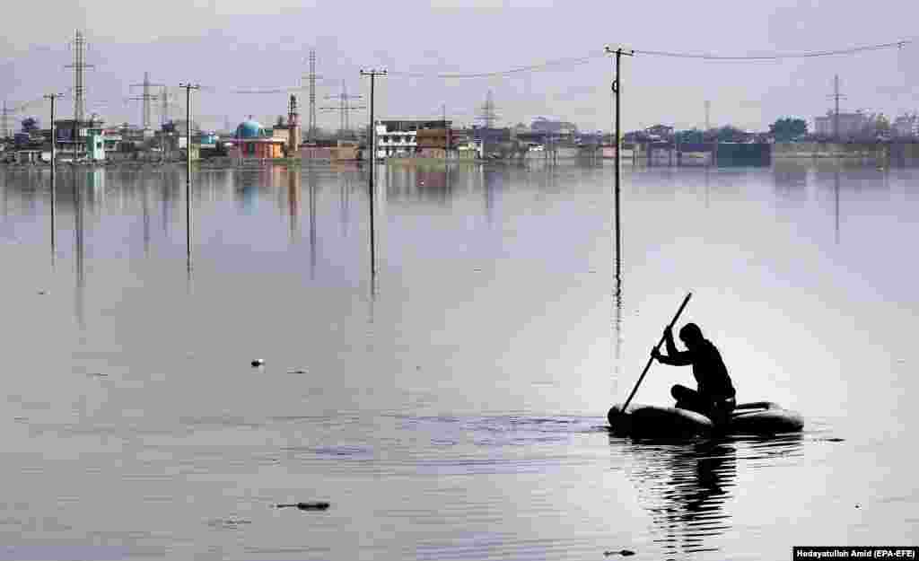 An Afghan man rides a makeshift boat in the Kol-e Hashmat Khan wetland on the outskirts of Kabul. (epa-EFE/Hedayatullah Amid)