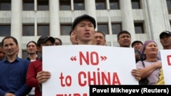 Мужчина в Алматы держит плакат с надписью: «Нет китайской экспансии». 4 сентября 2019 года.