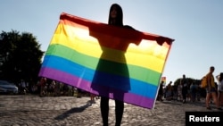 A demonstrator holds a rainbow flag at a rally in Budapest protesting against a law that bans LGBT content and materials in schools. (file photo)