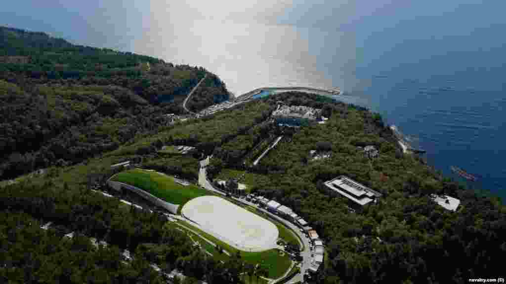 An aerial view shows the alleged hockey rink (bottom left) next to two helipads. The buildings on the curved road in the foreground are believed to be for the scores of construction workers who were visible in drone footage captured by Navalny&#39;s team.&nbsp;