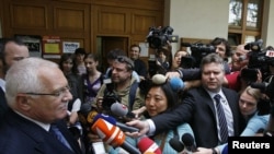 Czech President Vaclav Klaus answers questions as he leaves a polling station in Prague.