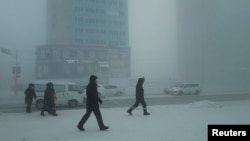 Pedestrians walk along a street in the city of Yakutsk in Siberia, which has been hit with an extreme cold snap.