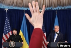 Журналісти піднімають руки, щоб поставити запитання президентам США і України за підсумками переговорів у клубі Трампа в Маямі. США, 28 грудня 2025 року