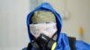 A health worker wearing a protective suit sprays disinfectant outside of a building during an awareness campaign for coronavirus disease (COVID-19), in the eastern city of Jalalabad on March 19.