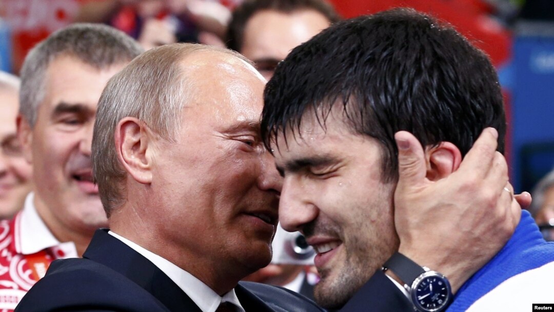 Russian President Vladimir Putin (left) congratulates Russia's Tagir Khaibulayev after he defeated Mongolia's Tuvshinbayar Naidan in their men's 100-kilogram final judo match at the London 2012 Olympic Games. 
