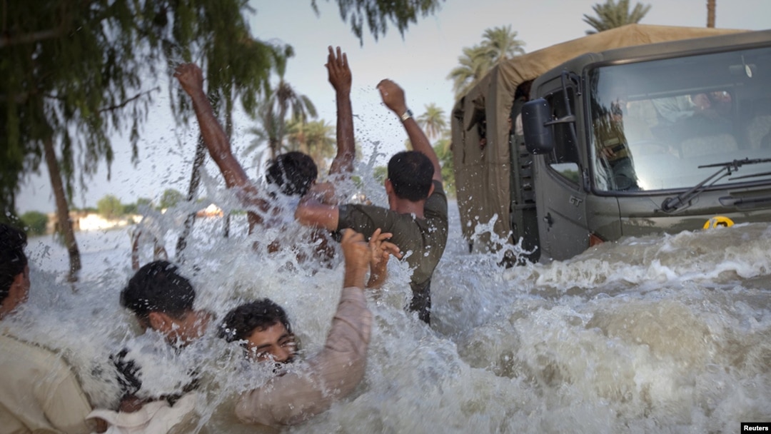 Residents evacuting through floodwaters dodge an army truck carrying relief supplies for flood victims in Pakistan's Muzaffargarh district of Punjab Province on August 11.