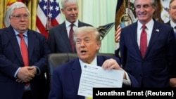 Президент США Дональд Трамп демонстрирует распечатку своего поста в Truth Social, Вашингтон, США, 4 июня 2026 года