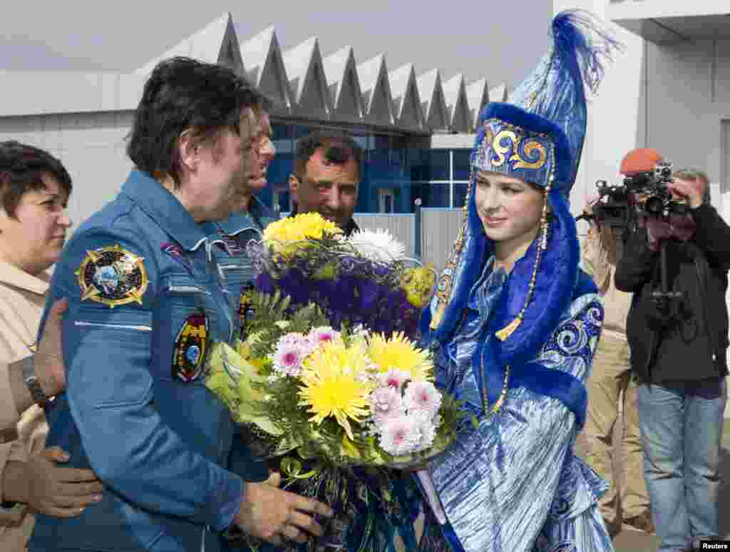 Revin is welcomed on his arrival to the city of Qostanai, the site of a forward base in northern Kazakhstan where the three were taken by helicopter.