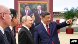 Лідер Китаю Сі Цзіньпін показує очільнику Росії Путіну фотовиставку про китайсько-російські відносини. Пекін,  20 травня 2026 року