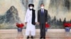 Taliban co-founder Mullah Abdul Ghani Baradar and Chinese Foreign Minister Wang Yi pose for a photo during their meeting in Tianjin on July 28.