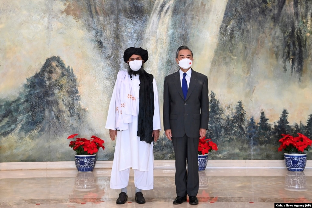 Taliban co-founder Mullah Abdul Ghani Baradar and Chinese Foreign Minister Wang Yi pose for a photo during their meeting in Tianjin on July 28.