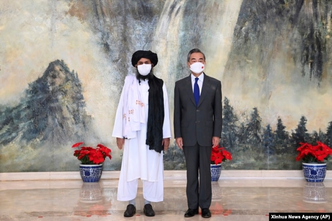 "Talibannıñ" negizin qalauşılardıñ biri molla Abdul Ğani Baradar (sol jaqta) men Qıtay sırtqı ister ministri Van I. Tyan'czin', Qıtay. 28 şilde 2021 jıl.