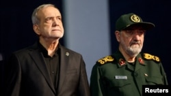 Iranian President Masud Pezeshkian (left) and Mohsen Rezaei, an adviser to Iran's supreme leader, attend a farewell ceremony for Iran's late Supreme Leader Ayatollah Ali Khamenei, in Tehran, July 3.