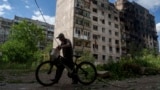 Місцевий житель іде з велосипедом повз будинок, який був зруйнований російською авіацією в Торецьку, Донецька область, Україна, 28 червня 2024 року