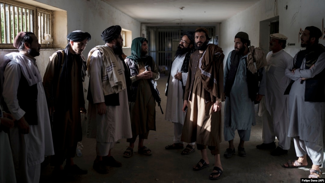 Taliban fighters chat with former prisoners after their release at the Pul-e Charkhi Prison in Kabul on September 13.