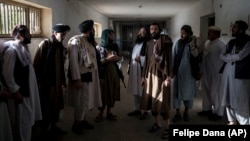 Taliban fighters chat with former prisoners after their release at the Pul-e Charkhi Prison in Kabul on September 13.