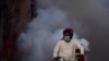 As a preventive measure against the coronavirus health workers on motorbike fumigate along a street in the southern Pakistani city of Hyderabad on March 15